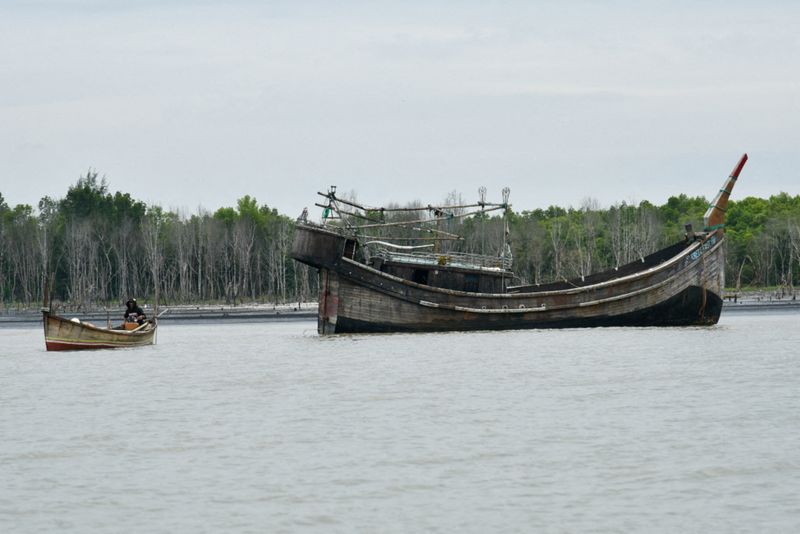 FILE PHOTO: A wooden boat that carried Rohingya Muslims floats off the coast of Karang Gading village