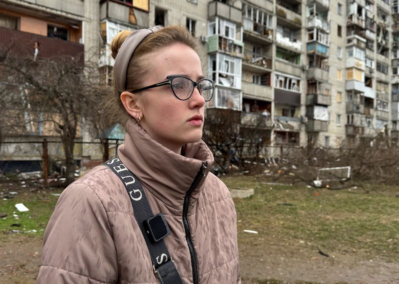 Anna Serdiuk, 18, stands near her apartment building hit by yesterday's Russian missile strike, amid Russia's attack on Ukraine, in Sumy, Ukraine March 25, 2025. REUTERS/Stringer