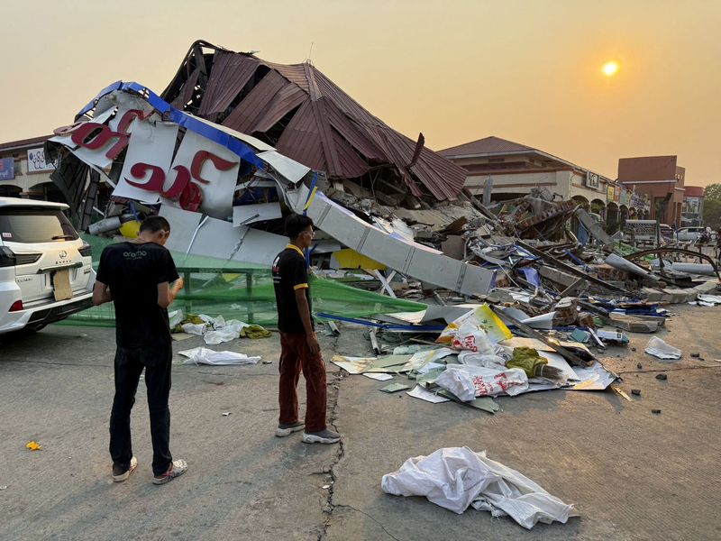 People stand near a commercial facility which collapsed due to an earthquake, in Naypyitaw, Myanmar March 29, 2025, in this photo released by Kyodo. Kyodo/via REUTERS