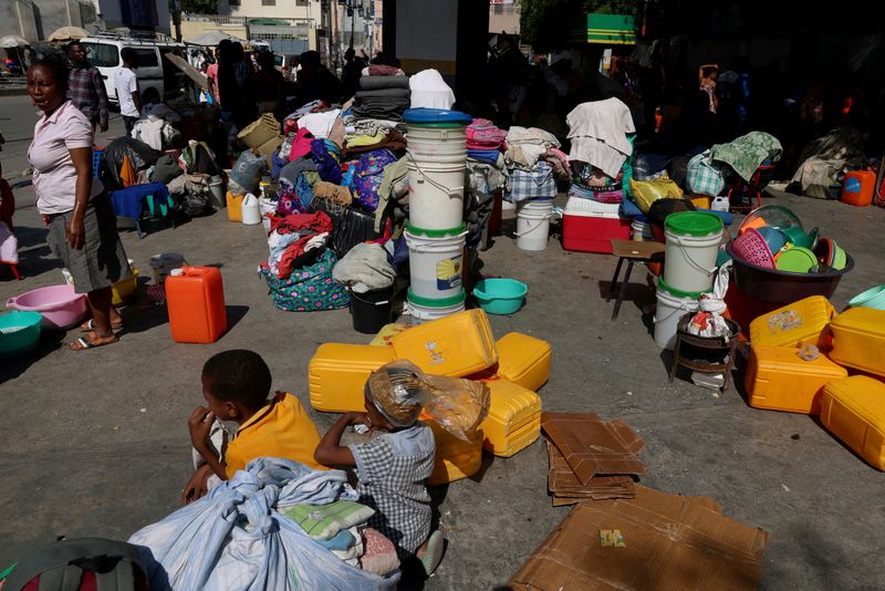 FILE PHOTO: A member of the Haitian army patrols as people shelter at a petrol station after fleeing their neighborhoods amid ongoing gang violence, in Port-au-Prince, Haiti, March 19, 2025. REUTERS/Ralph Tedy Erol/File Photo
