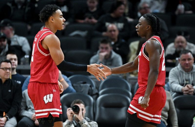 Dec 14, 2024; Indianapolis, Indiana, USA; Wisconsin Badgers guard John Tonje (9) and guard John Blackwell (25) react after a play during the first half against the Butler Bulldogs at Gainbridge Fieldhouse. Mandatory Credit: Robert Goddin-Imagn Images