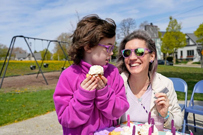 Stella Schneider, 9, enjoys her birthday cupcake with her mother Rese on Wednesday, May 7, 2025 at Kilbourn Reservoir Park in Milwaukee. Stella understood that the playgrounds in Milwaukee didn't accommodate her disabilities. Her mother set out to help create the first universally accessible playground in the City of Milwaukee. The new park at the same location as plans for an inclusive basketball courts, musical play features, creativity play areas, accessible bathroom and shared seating areas.