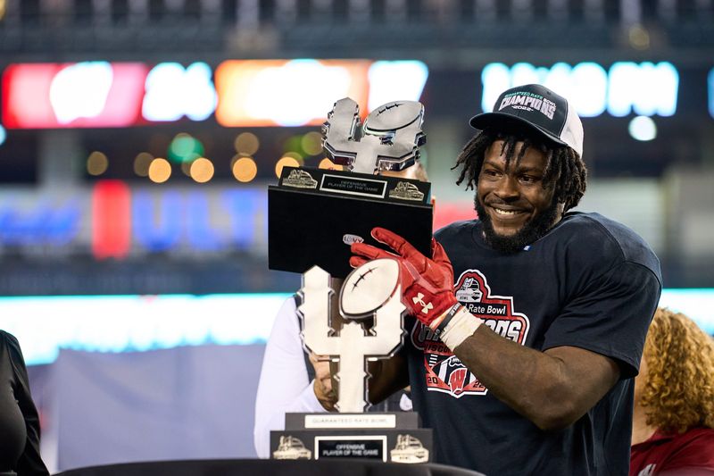 Defensive MVP Wisconsin Badgers linebacker Jordan Turner (54) holds his trophy during the Guaranteed Rate Bowl Game at Chase Field on Tuesday, Dec. 27, 2022.

Ncaa Guaranteed Rate Bowl
