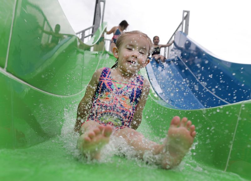 Cambrie Smit slides on a water slide during opening day at Erb Pool on June 8, 2018 in Appleton, Wisconsin